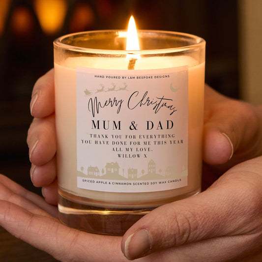 Candle with a personalized label held in hands against a warm background